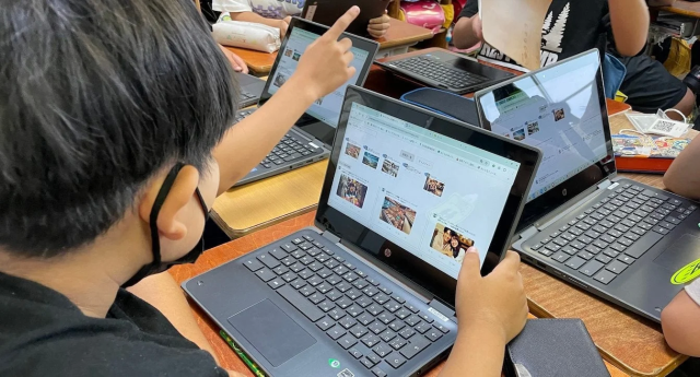 教室でラップトップを使い学習する生徒たち