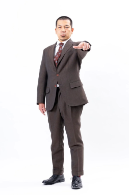 茶色のスーツを着て指差しをする天竺川原さん