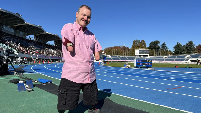 義肢の男性が陸上トラックに立つ様子