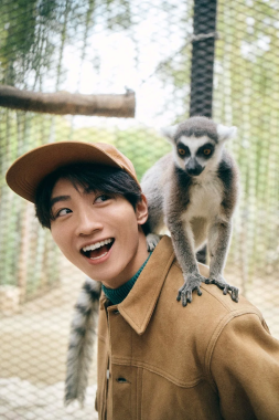 肩にワオキツネザルを乗せ笑顔の木村魁希さん