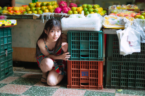 市場でしゃがむ金澤亜美さん