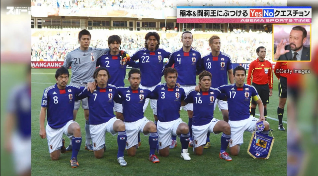 サッカー日本代表チームがピッチで集合写真を撮っている様子